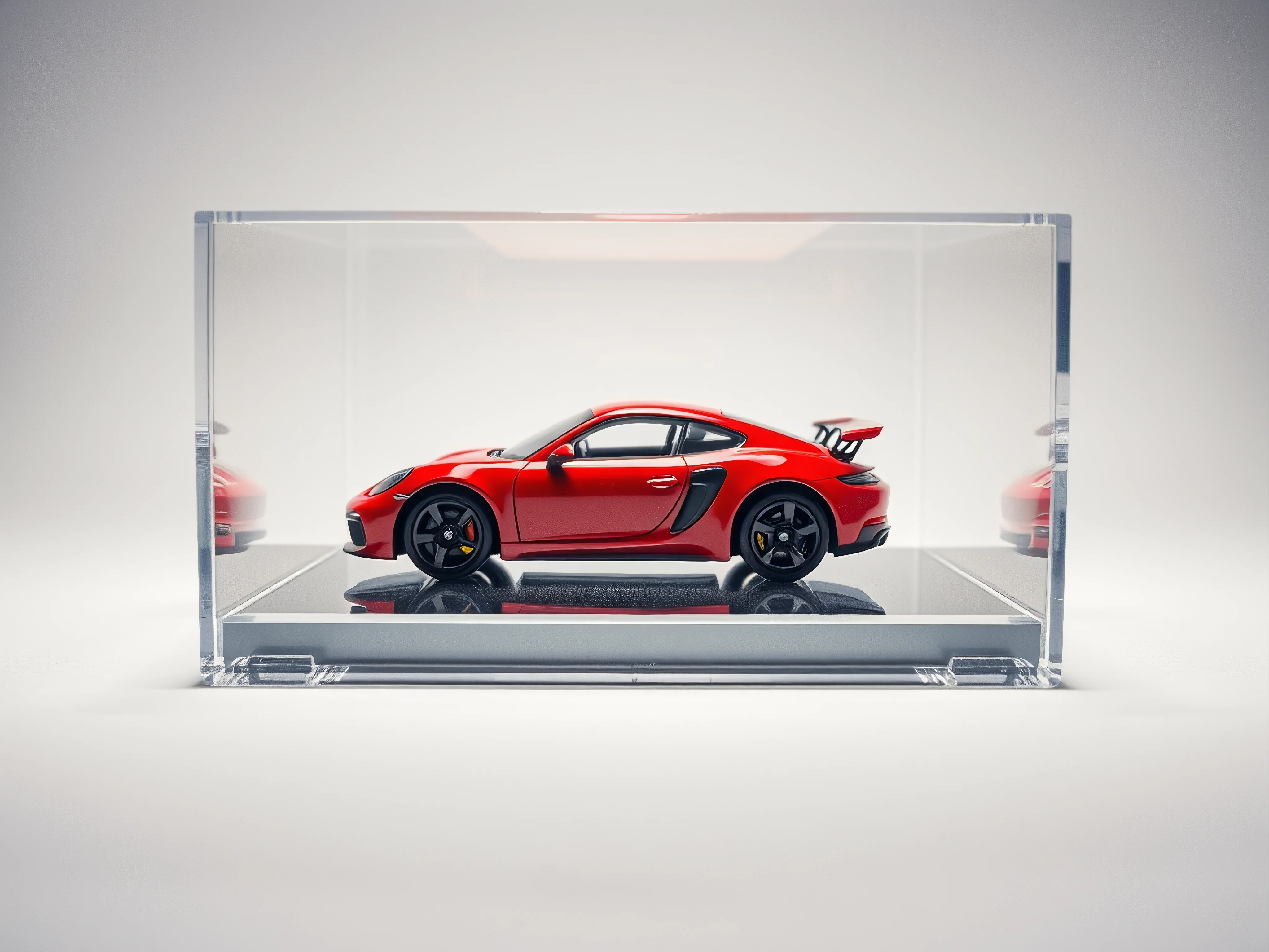 Vibrant miniature model car in clear acrylic display case on a pristine white background.